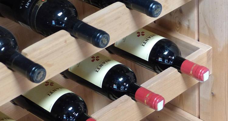 Bouteilles de vin soigneusement rangées sur un porte-bouteilles en bois.
