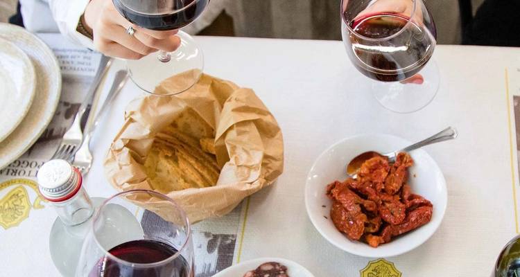 Des gens qui profitent de vin et de nourriture sur une table.