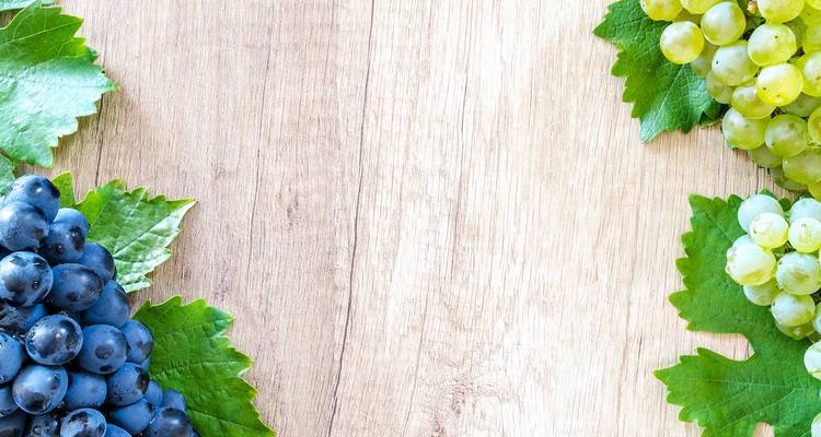 Raisins assortis sur une planche en bois.