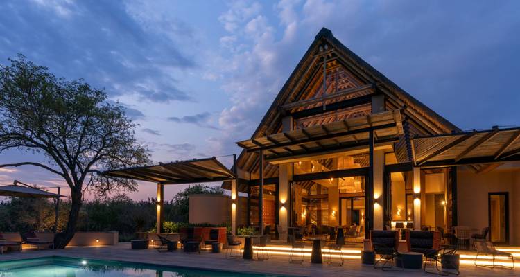Luxuriöse Lodge an einem Pool bei Sonnenuntergang