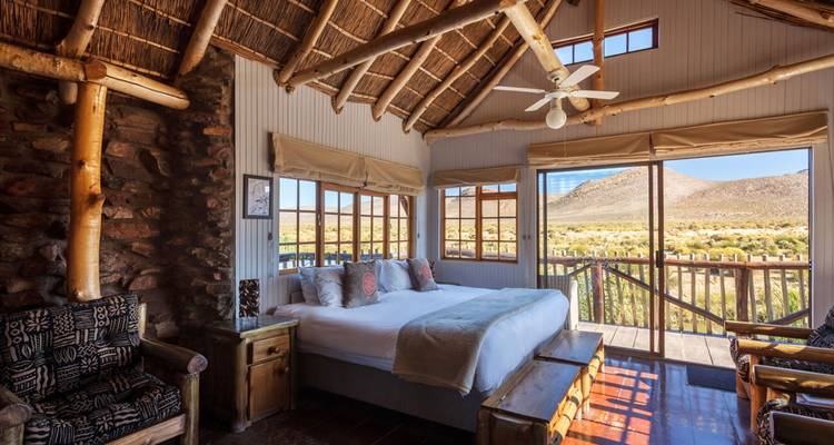 Rustikales Hütteninterieur mit Holzmöbeln und Bergblick