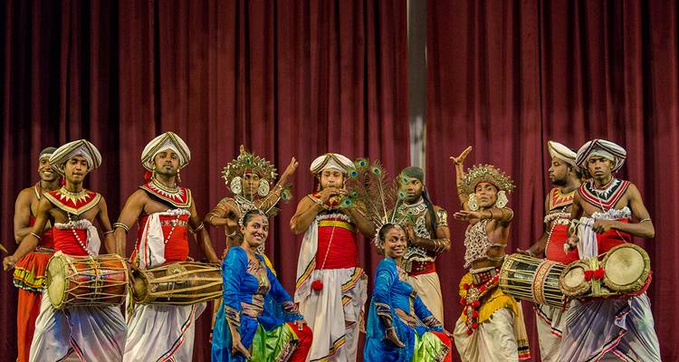 Des artistes en tenues traditionnelles sur une scène, présentant une danse culturelle.