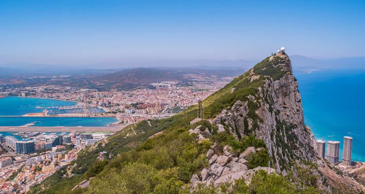 Le spectaculaire rocher de Gibraltar s'élève au-dessus de la ville et de la mer Méditerranée azur avec la piste d'aéroport visible.