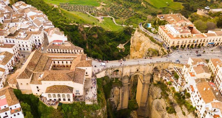 Dronebeeld van Ronda's witgekalkte stadje hoog bovenop dramatische rotsen verbonden door de Puente Nuevo