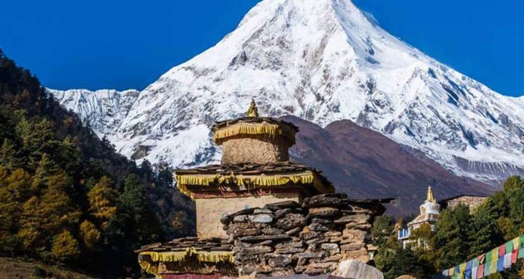 Une structure traditionnelle sur une montagne avec des drapeaux de prière.