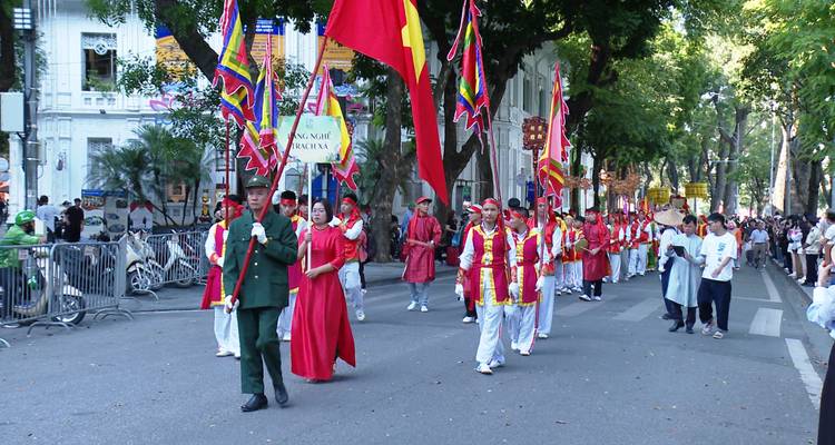 Défilé traditionnel avec des personnes en costumes colorés marchant dans une rue.