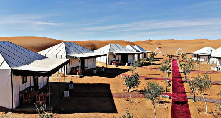 Desert camp with white tents.