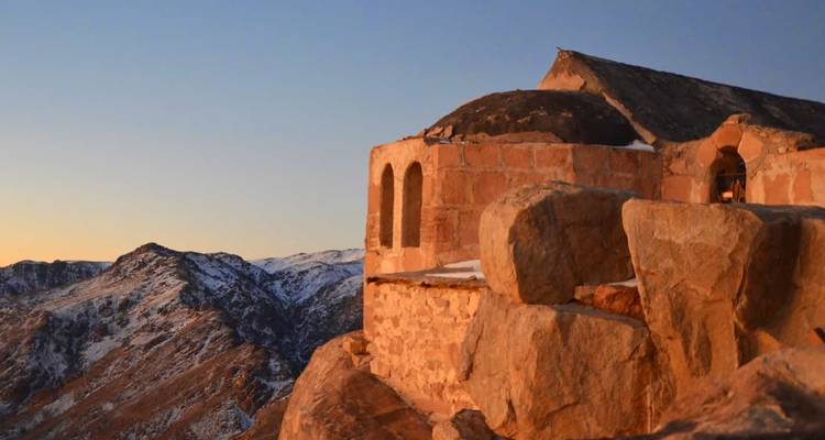 Edificio de piedra en la ladera de una montaña durante la hora dorada.