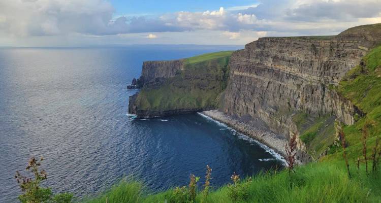 Sheer vertical sea cliffs plunge into the Atlantic with emerald headlands stretching to the horizon.