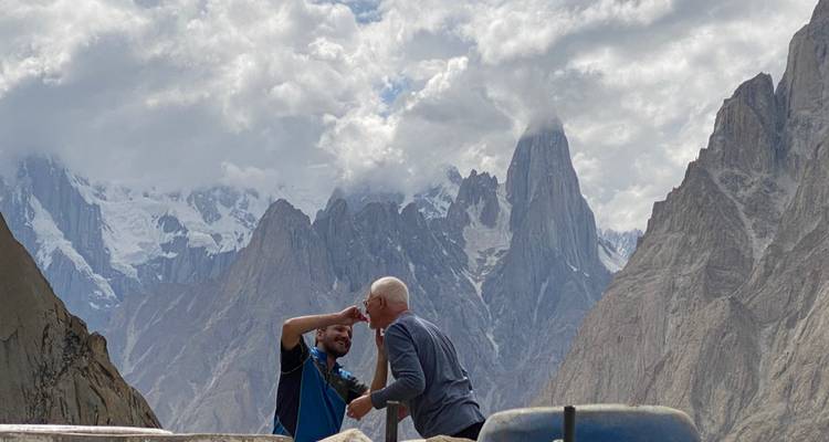 Dos personas abrazándose con montañas de fondo.