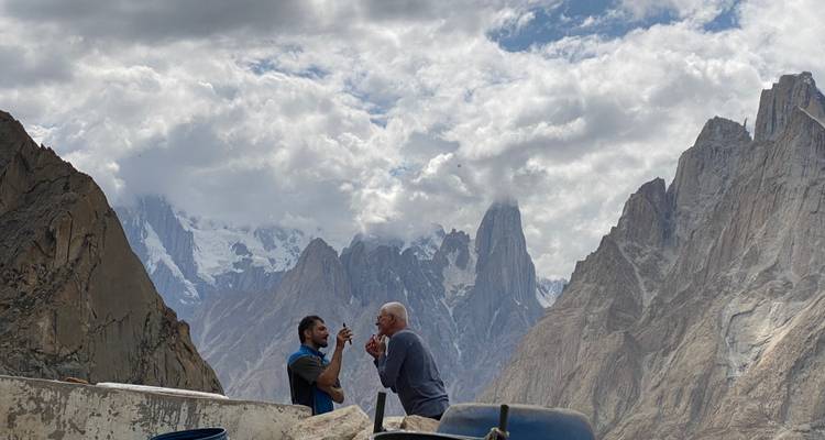Dos personas paradas en un sendero rocoso en las montañas.