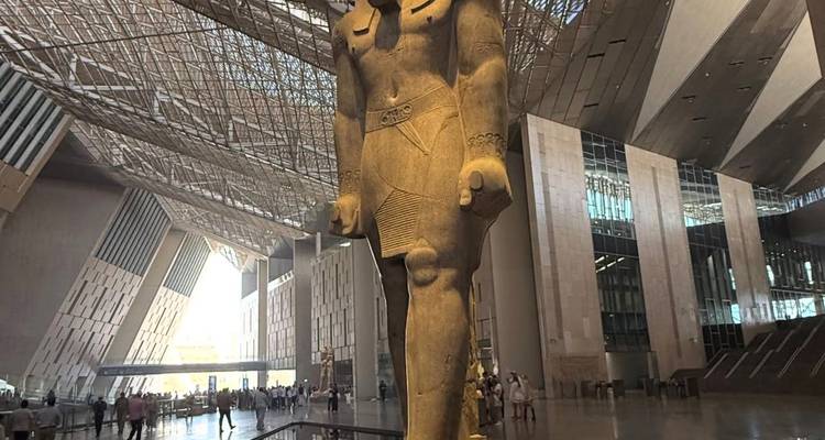 Grande statue à l'intérieur d'un musée moderne avec des gens qui se promènent.