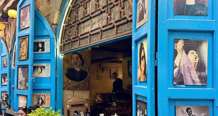 Devanture de magasin avec des photos de célébrités et des décorations traditionnelles.