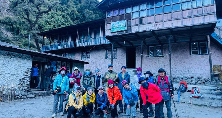 Groupe de randonneurs posant devant une maison d'hôtes au Népal.