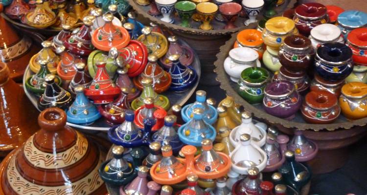 Poterie colorée disposée de manière rapprochée dans un étalage de marché.