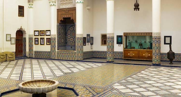 Intérieur orné d'un musée avec des sols carrelés et des artefacts exposés.