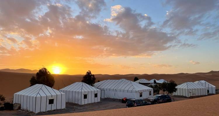Tent camp in the desert at sunset.