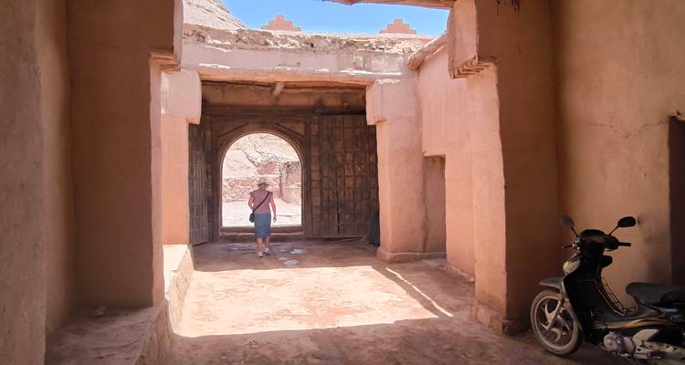 Un passage étroit à travers des bâtiments traditionnels avec une personne qui marche.