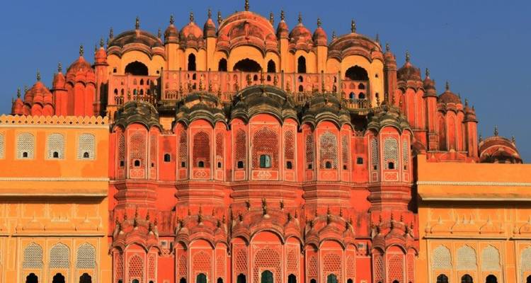Façade de palais au design complexe avec des teintes orange et rose.