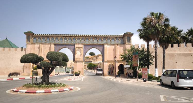 Porte historique avec arcades et arbres sur les côtés