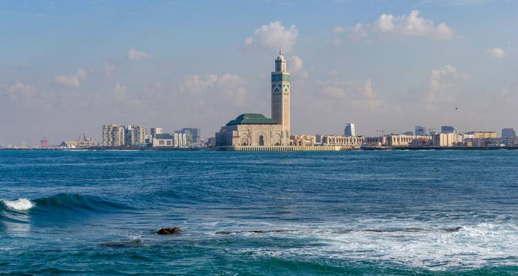 La Mosquée Hassan II au bord de la mer sous un ciel lumineux.