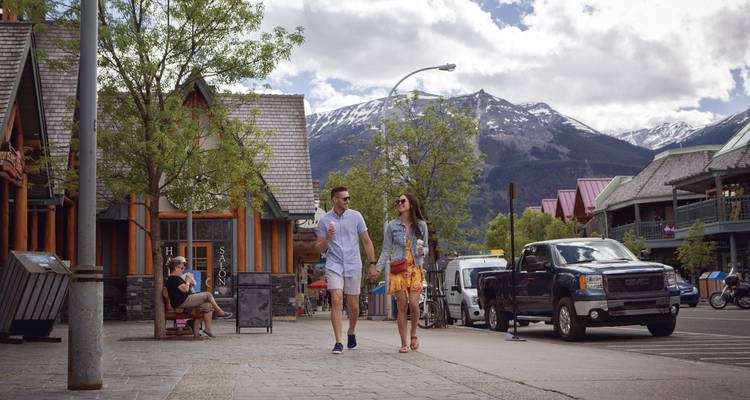 Couple walking in a mountainous town setting.