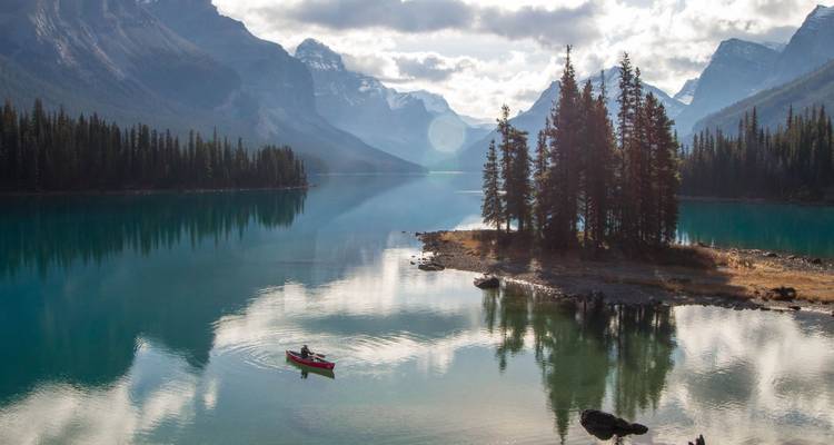 Kayak on a serene lake surrounded by mountains.