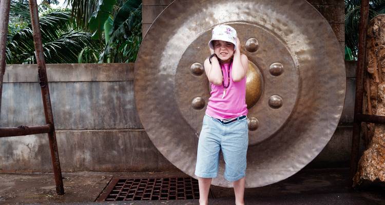 Enfant debout devant un grand gong.