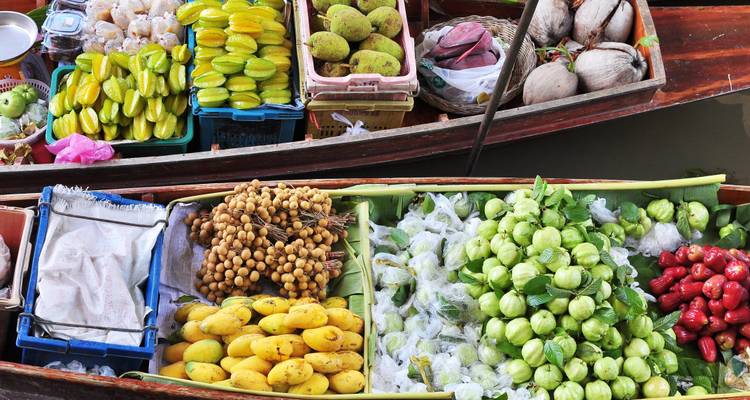 Marché flottant coloré avec des fruits et des produits sur des bateaux.