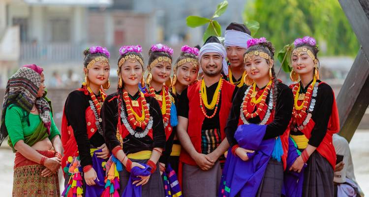 A group of people dressed in traditional colorful attire posing together.