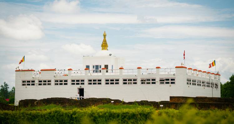 A white building with golden accents and flags decorating the structure.