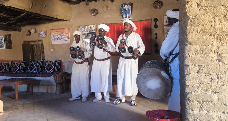 Mannen in traditionele kleding die instrumenten bespelen in een kamer.