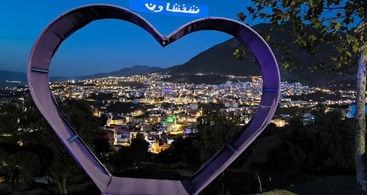 Hartvormige lijst met uitzicht op een stad 's nachts.
