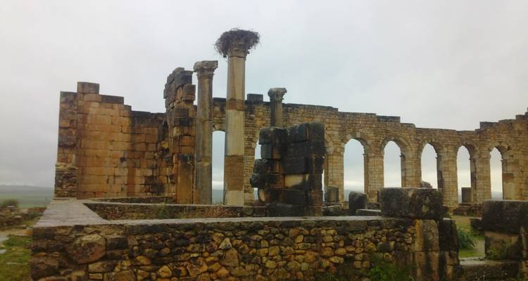 Ruïnes van een oude structuur met door het weer verweerde stenen zuilen.