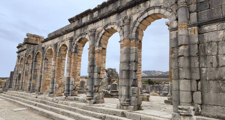 Arches de pierre et vestiges de ruines d'un site romain antique.