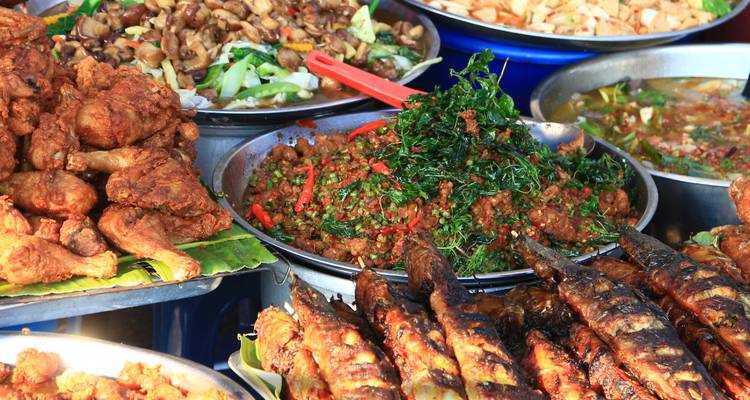 Un assortiment de plats de street food comprenant du poisson frit et des légumes.