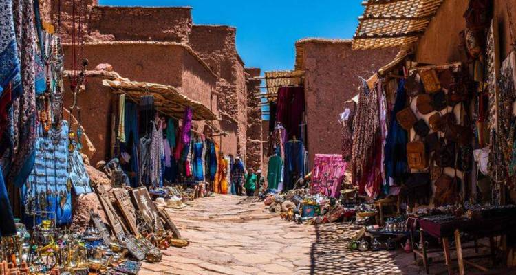Marktstraße mit bunten Textilien und Waren in der Auslage.