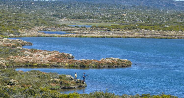 Menschen, die in einem malerischen See mit rauer Landschaft angeln.
