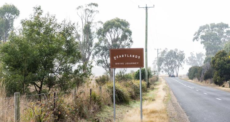 Landstraße mit einem Schild mit der Aufschrift „Heartlands".
