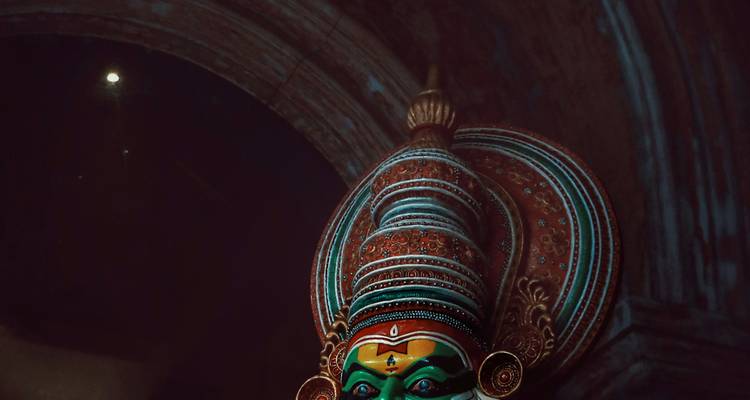 Masque traditionnel coloré dans un cadre faiblement éclairé.