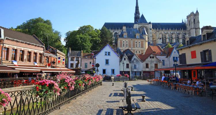 Eine charmante Straße mit bunten Häusern und einer Kathedrale im Hintergrund.