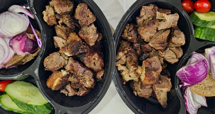 Platos de carne asada con verduras y pan.