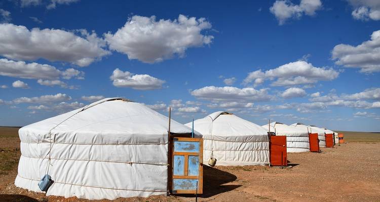 Fila de yurtas tradicionales bajo un cielo azul brillante.