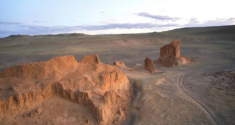 Formaciones rocosas en un paisaje desértico bajo un sol poniente.
