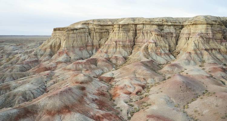 Formaciones rocosas con rayas en un vasto paisaje abierto.