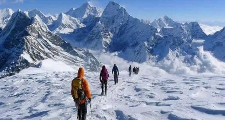 Alpinistes descendant une crête de montagne enneigée.