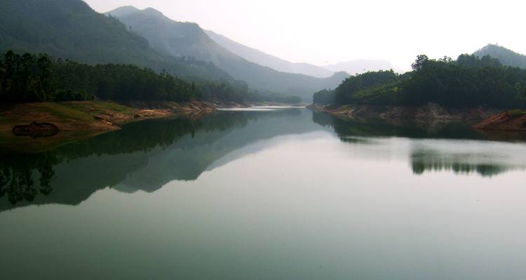 Réservoir de montagne serein reflétant les collines environnantes dans une lumière douce.