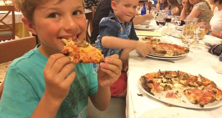 Enfants mangeant une pizza à une table.