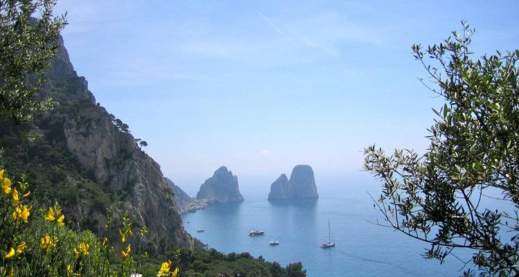 Vue panoramique du littoral avec des formations rocheuses lointaines dans la mer.
