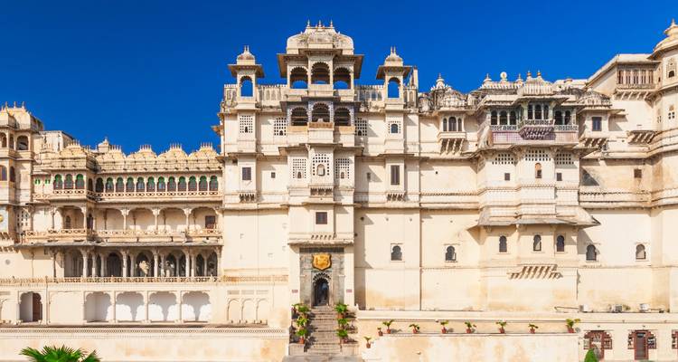 White-walled palace with intricate balconies and a royal entrance.